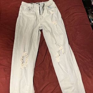 Light blue jeans, ripped at knees, wide leg